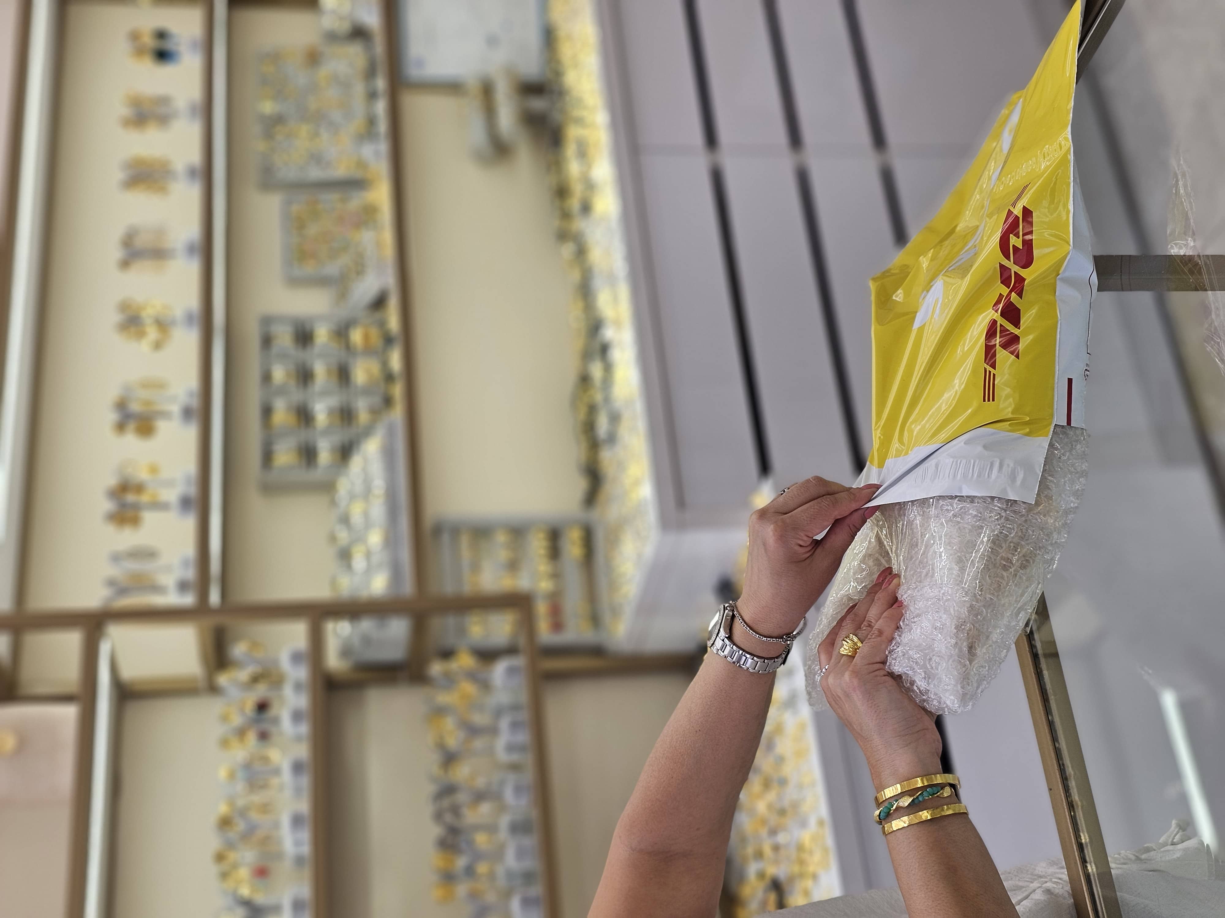 Bubble-wrapped order being sealed into a DHL courier satchel