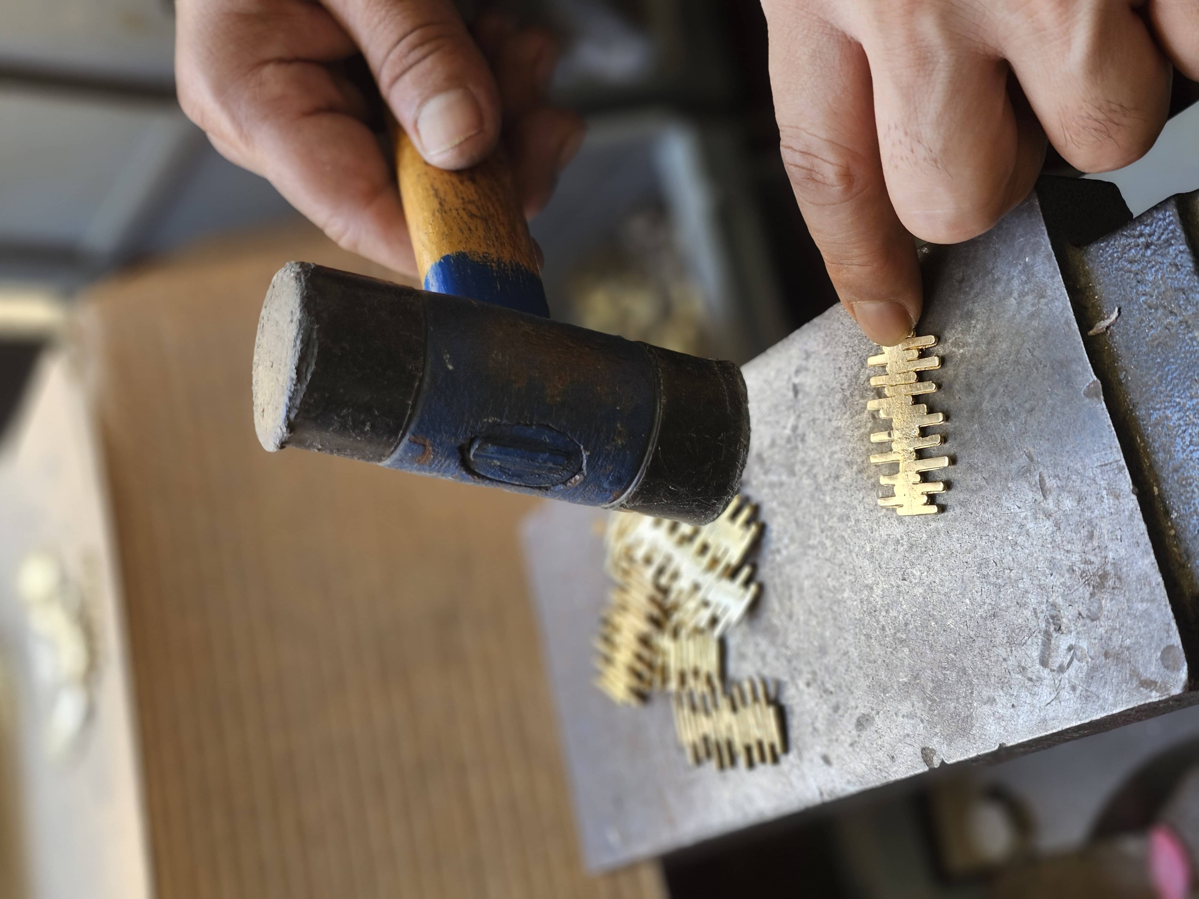 Artisan working a cast piece with a small hammer