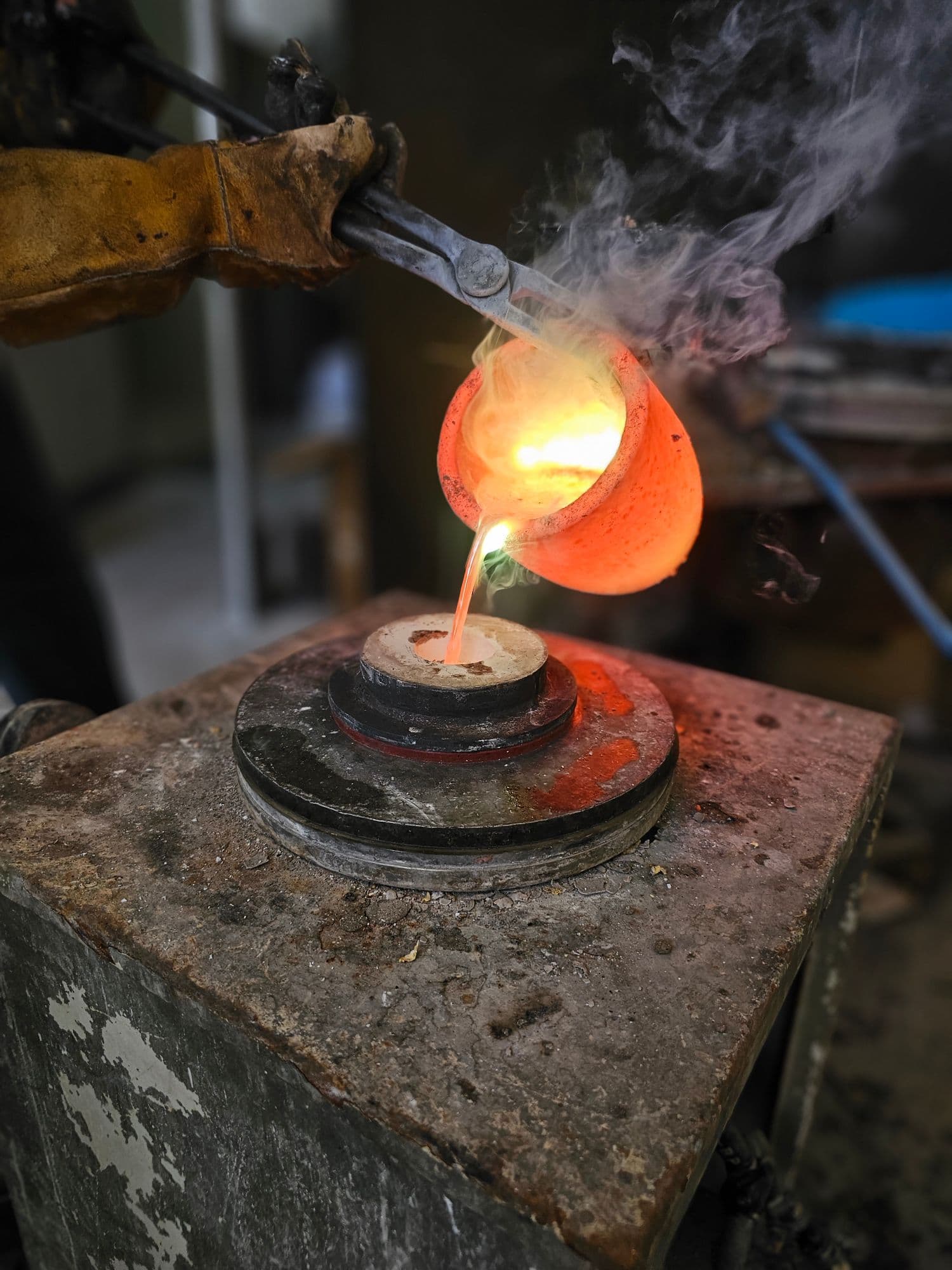 Molten metal poured from a glowing crucible into a casting flask