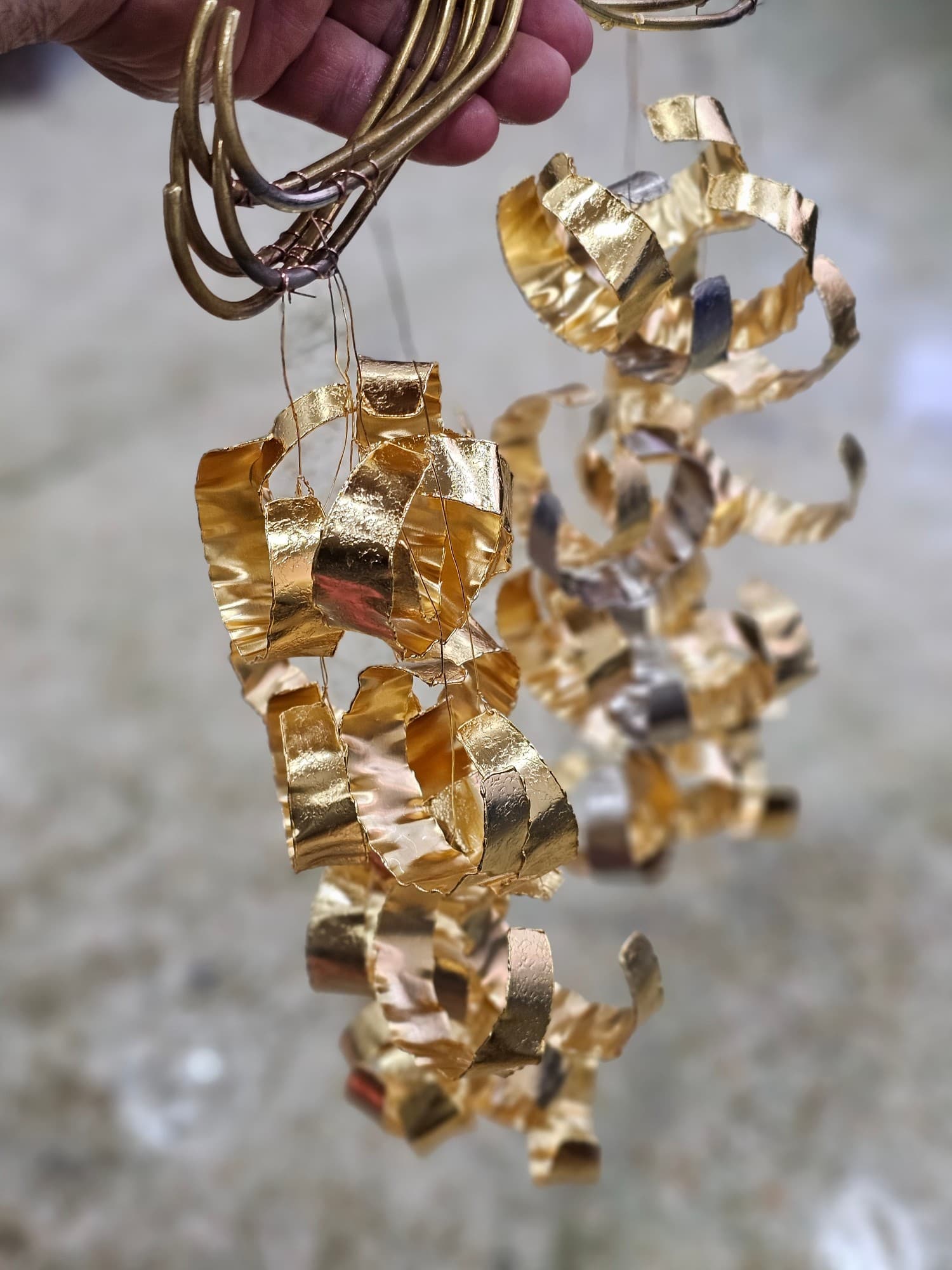 Freshly gold-plated pieces hanging from plating wires